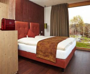 a bedroom with a large bed with a large window at Triad Wiener Alpen Bett DZ in Bad Schönau