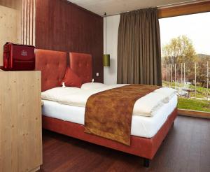 a bedroom with a large bed with a large window at Bett in der Wies´n, Restaurant Triad in Bad Schönau