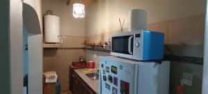 a microwave on top of a refrigerator in a kitchen at Casa Bonita in Juella