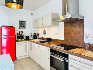 a kitchen with white cabinets and a red refrigerator at L'Oasis -T4 Garage Clim Terrasse WIFI Centre-Ville in Villefranche-sur-Saône +28 photos