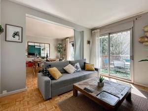 a living room with a couch and a table at L'Oasis -T4 Garage Clim Terrasse WIFI Centre-Ville in Villefranche-sur-Saône