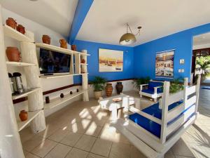 a living room with blue walls and white shelves at Hotel Porto das Ancoras in Porto Seguro