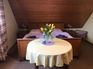a table with a vase of yellow flowers on it at Retro Ferienwohnung mit Schlossblick im Nordschwarzwald in Altensteig