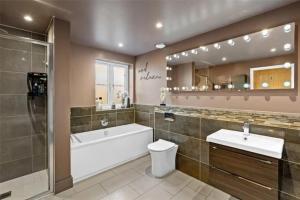 a bathroom with a tub and a toilet and a sink at St Chloe in Layer de la Haye +33 photos
