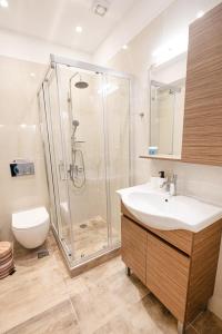 a bathroom with a shower and a sink and a toilet at XENIOS APARTMENTS in Poros