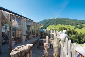 a building with a fence and a view of a mountain at Apartmenthaus Rosenhof in Alpbach