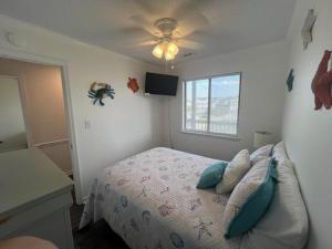 1 dormitorio con 1 cama y ventilador de techo en Sea Shadow 205 Condo en Myrtle Beach