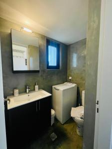 bagno con lavandino, servizi igienici e specchio di Waves House a Kíssamos