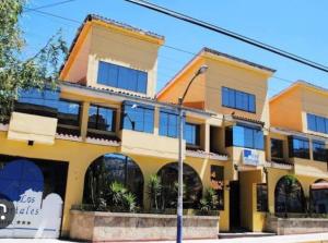 un edificio amarillo con ventanas en una calle en Hotel Los Portales en Huaraz
