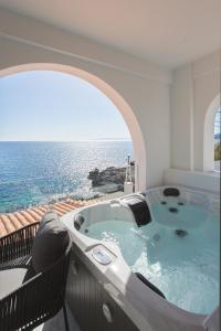 a hot tub on a balcony with the ocean at Marina Apartments in Kardamili