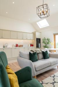 a living room with a couch and a kitchen at Debbie's Cottage at Tullig House & Farm in Killarney