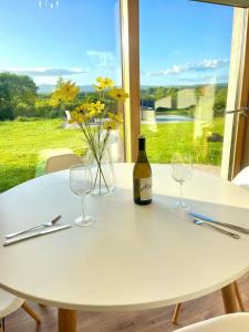 uma mesa branca com dois copos e uma garrafa de vinho em Debbie's Cottage at Tullig House & Farm em Killarney