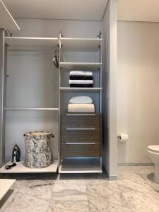 a bathroom with a closet with towels and a toilet at Blue & Yellow Apartment HP - Sur in Mexico City