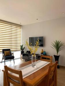 un salon avec une table et un vase de fleurs dans l'établissement Blue & Yellow Apartment HP - Sur, à Mexico