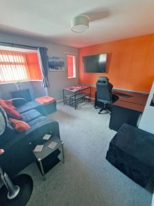 a living room with a couch and a desk at Beautiful 3BR Home with Garden & Gym in Hull
