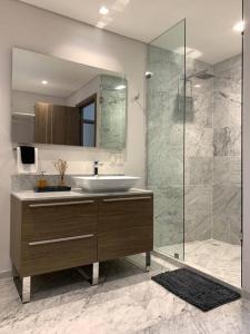 La salle de bains est pourvue d'un lavabo et d'une douche en verre. dans l'établissement Blue & Yellow Apartment HP - Sur, à Mexico