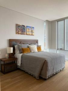 a bedroom with a bed and a table with a lamp at Blue & Yellow Apartment HP - Sur in Mexico City