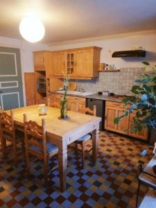 La Maisonnette de Suzette في Port-sur-Saône: مطبخ مع طاولة خشبية مع كراسي وطاولة