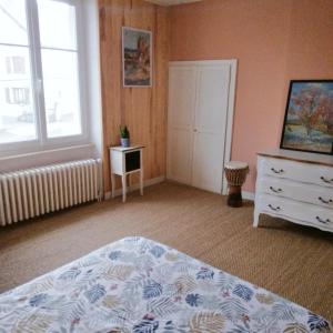 ein Schlafzimmer mit einem Bett, einer Kommode und einem Fenster in der Unterkunft La Maisonnette de Suzette in Port-sur-Saône