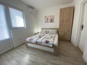 a bedroom with a bed and a wooden door at Guesthouse Apartments Čenić in Budva