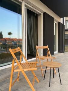 two wooden chairs and a table on a balcony at Apartment Toucan in Jarocin