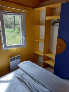 a bedroom with a bed and a window and shelves at Chalet 6 places in Saint-Thomas-en-Royans