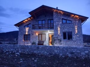 uma casa de pedra com luzes na frente em Vila Nikol em Voskopojë