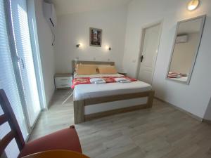 a bedroom with a bed and a mirror at Guesthouse Apartments Čenić in Budva