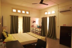 ein Krankenhauszimmer mit einem Bett und zwei Fenstern in der Unterkunft Cozy Haven in Jorhat
