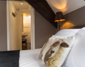 ein Bett mit einem Kissen mit einem Hund drauf in der Unterkunft B&B De zilveren reiger in Middelburg