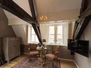 um quarto com uma mesa e cadeiras e uma janela em B&B De zilveren reiger em Middelburg