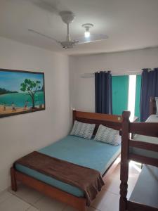 een slaapkamer met een bed en een foto van een strand bij Aloha Suites in Cabo Frio