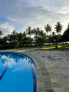 a blue swimming pool with palm trees in the background at Baharia Blue Studio in Diani Beach
