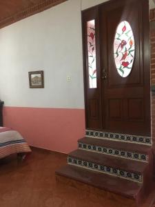 a room with a wooden door with a window at Olivos Habitación cuádruple in Tequisquiapan