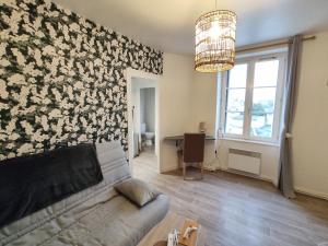 a living room with a couch and a flower wall at Le 5, Wifi, Parking, Centre in Châteauroux