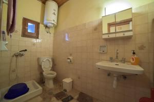 uma casa de banho com um lavatório, um WC e um lavatório. em Mary's Garden House em Peroulades