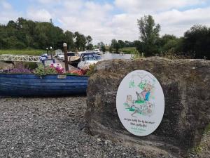 a sign on a rock next to a boat at Killynick Marina Glamping Rose in Fivemiletown