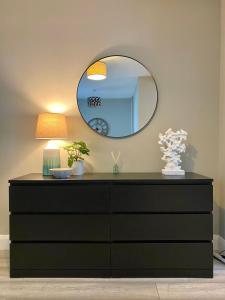 a dresser in a room with a mirror at Bailey’s Townhouse in Belfast