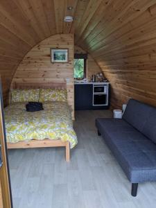a bedroom with a bed and a couch in a cabin at Killynick Marina Glamping Rose in Fivemiletown