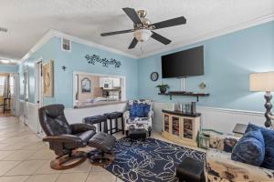 a living room with blue walls and a ceiling fan at Sea Breeze 311 in Gulf Shores