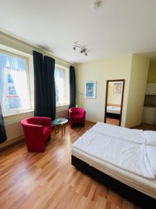1 dormitorio con 1 cama, 2 sillas y mesa en Pension Appartementhaus Hus Möhlenbarg, en Cuxhaven