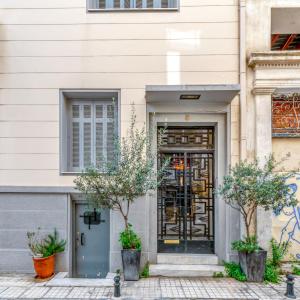 una puerta a un edificio con árboles delante de él en Plaka Sofi Suite en Atenas
