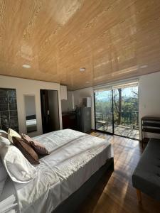 a bedroom with a large bed with a wooden ceiling at Mirador Entre Bosque, Escapada Romantica in Rionegro