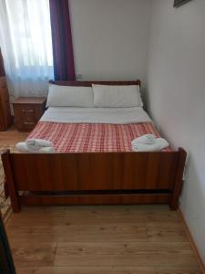 a bed with a wooden frame with two towels on it at GUEST HOUSE “ Center Theth “ in Theth