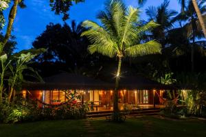 a house with a palm tree in front of it at Bahia Soul - Casa Mutá - Barra Grande - Península de Maraú in Barra Grande