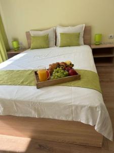 bandeja de fruta en una cama con dos bebidas en Уютен нов апартамент - Стара Загора en Stara Zagora