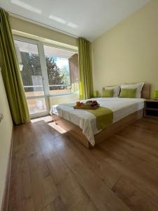 a bedroom with a large bed and a large window at Уютен нов апартамент - Стара Загора in Stara Zagora