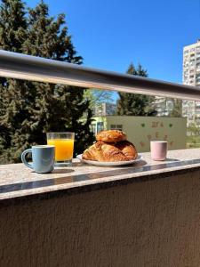 una mesa con un plato de bollería y una taza de zumo de naranja en Уютен нов апартамент - Стара Загора en Stara Zagora
