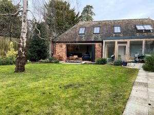 a brick house with a patio and a yard at The Old Estate Yard, Dumbleton - Near Broadway in Dumbleton