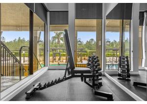 una habitación con un gimnasio con banco y ventanas en Luxury Model Townhome - 5 minutes from Disney, en Orlando
